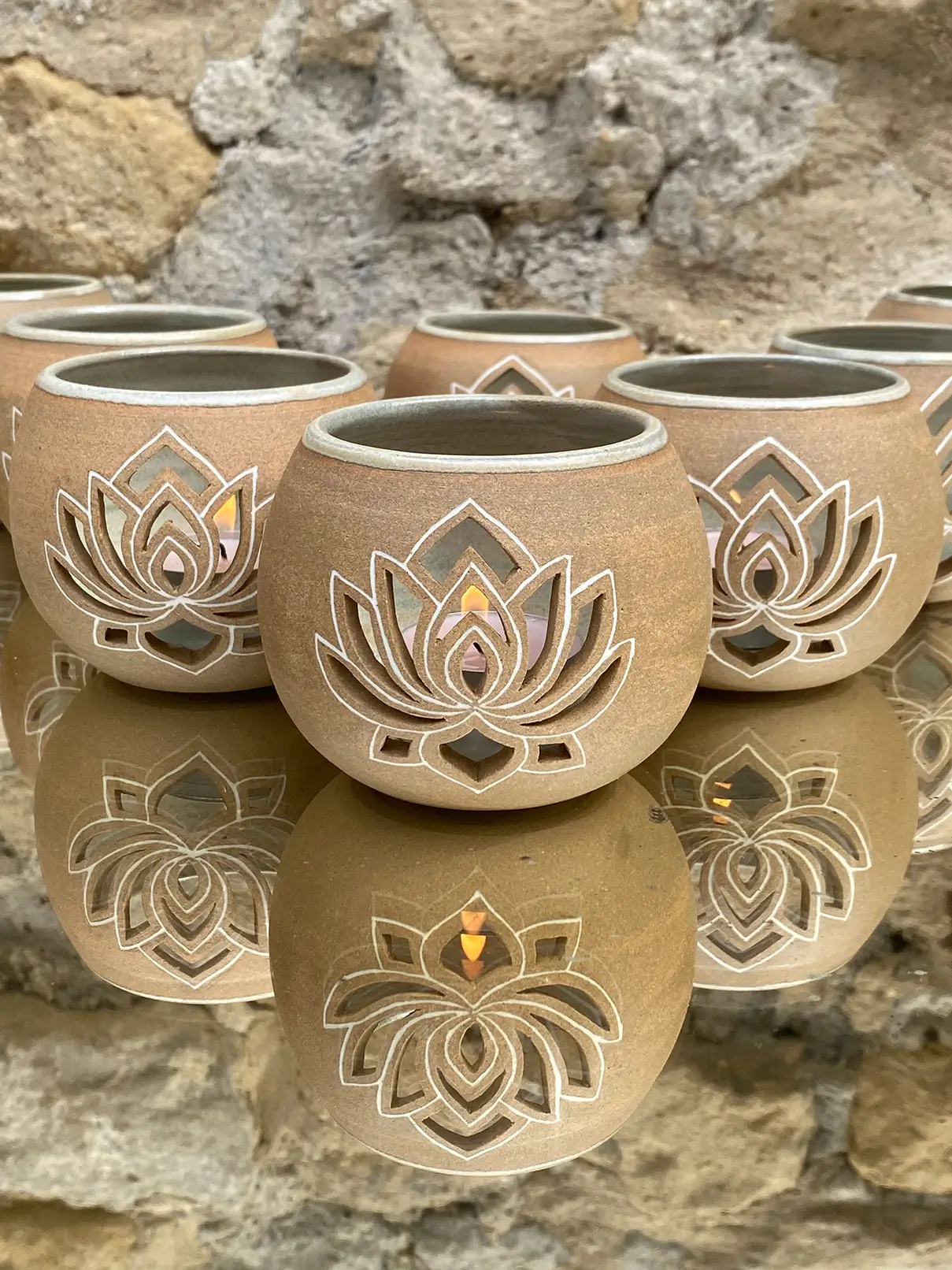 Photophores lotus en céramique artisanale réalisés à la main par Armelle Gallina, diffusant une lumière douce inspirée de la symbolique sacrée du lotus