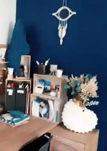 Attrape-rêve en céramique accroché dans un atelier Attrape-rêve en céramique accroché au mur bleu d’un atelier, chez une cliente